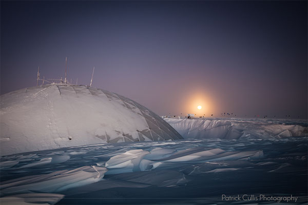 The moon shines on the horizon behind the Dome Station at the Amundsen-Scott South Pole Station, Antarctica